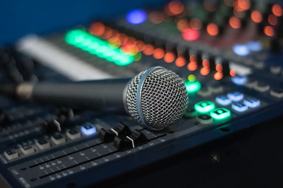 Image of a microphone on top of an audio mixer. Source: unsplash