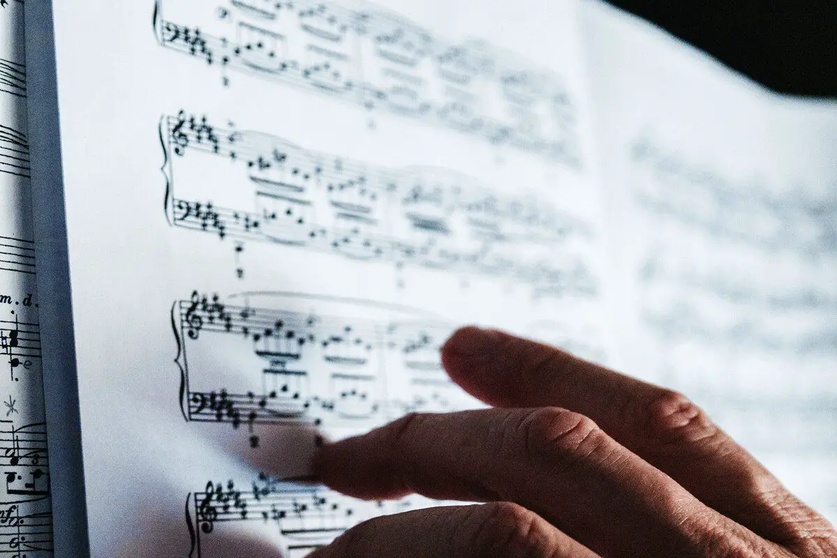 Image of a person reading a music sheet unsplash