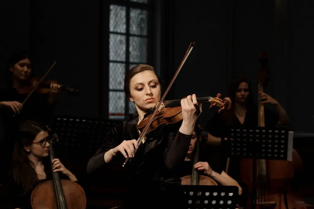 Image of a woman playing a violin. Source: pexels