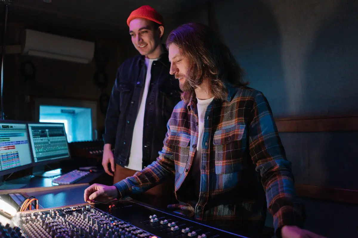 Image of audio engineers adjusting mixers in the studio. Source: unsplash