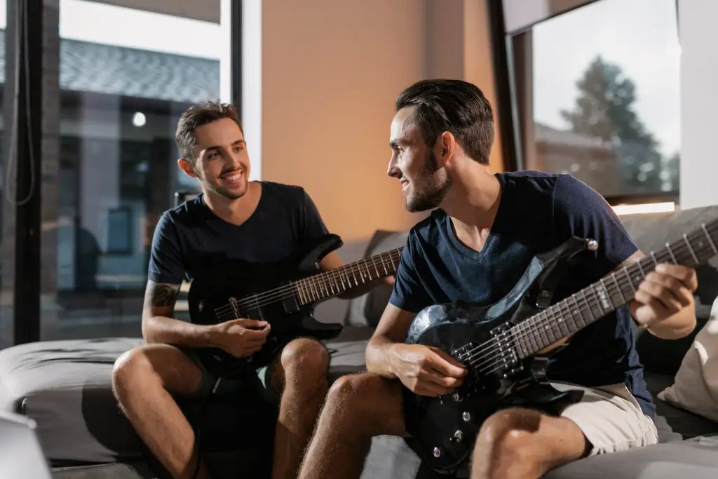 Two men playing electric guitars. Source: pexels