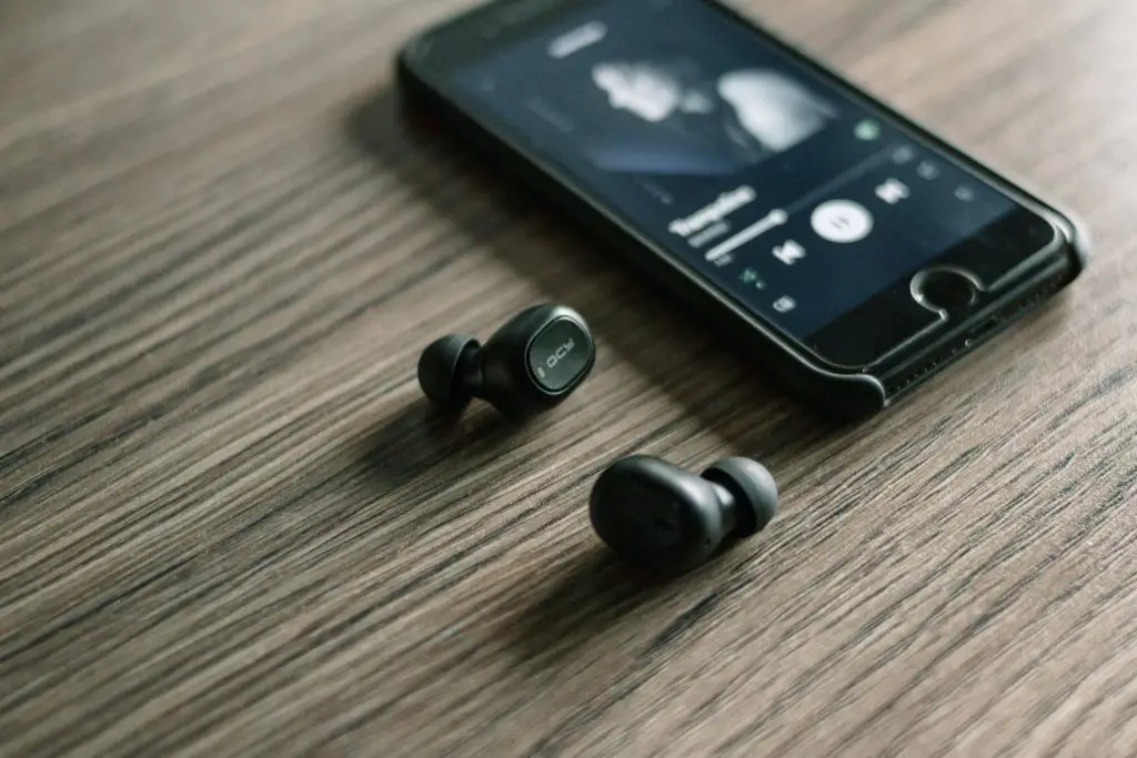 Image of a smartphone and pair of wireless earbuds. Source: unsplash.