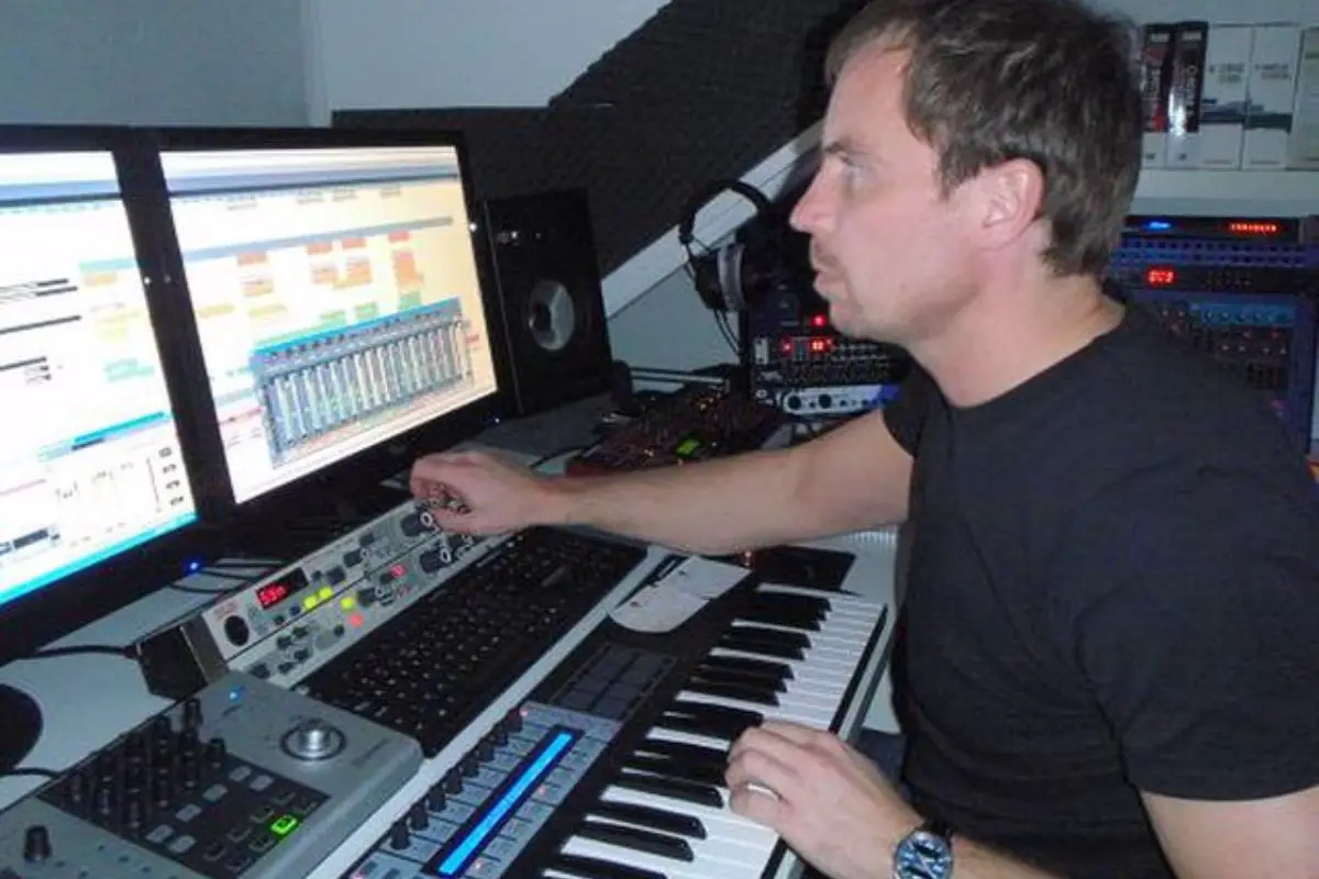 Image of a man working on his computer inside a home studio.
