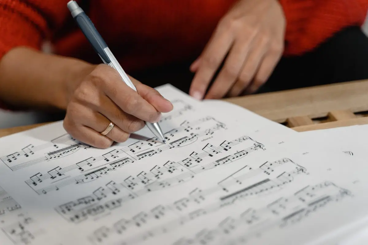 Image of a musician checking musical notations in a sheet music.