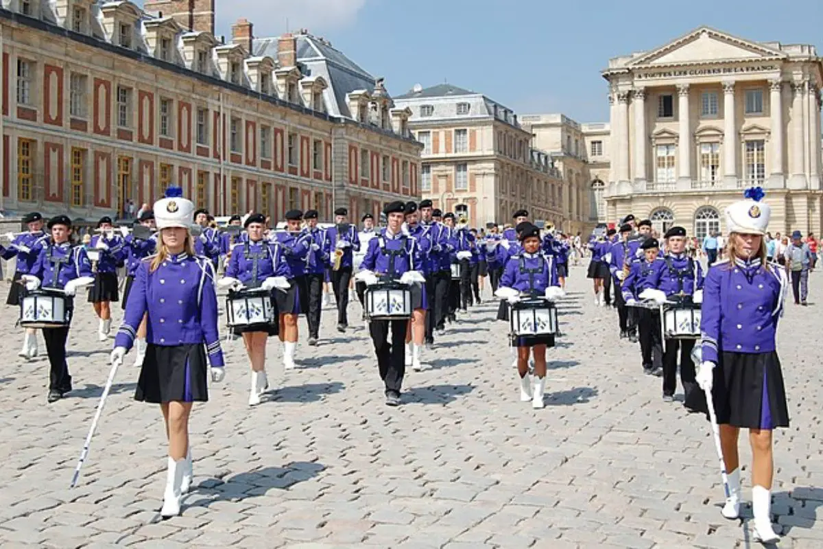 Image of a performing marching band wearing blue uniform.