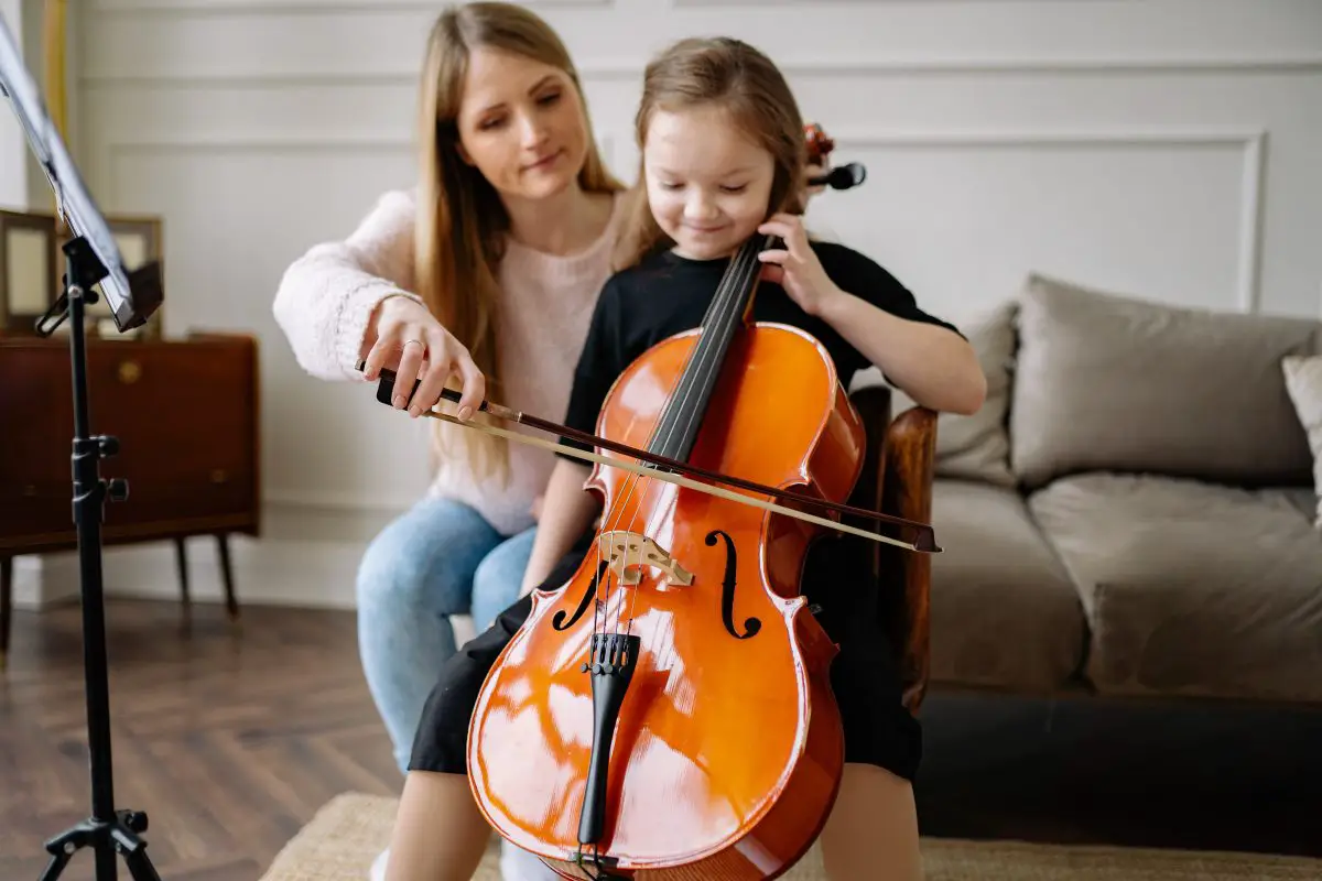 Image of a woman and a girl playing the cello together.