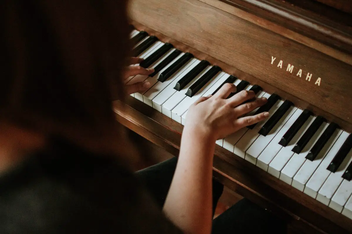 Image of a woman playing a grand piano.