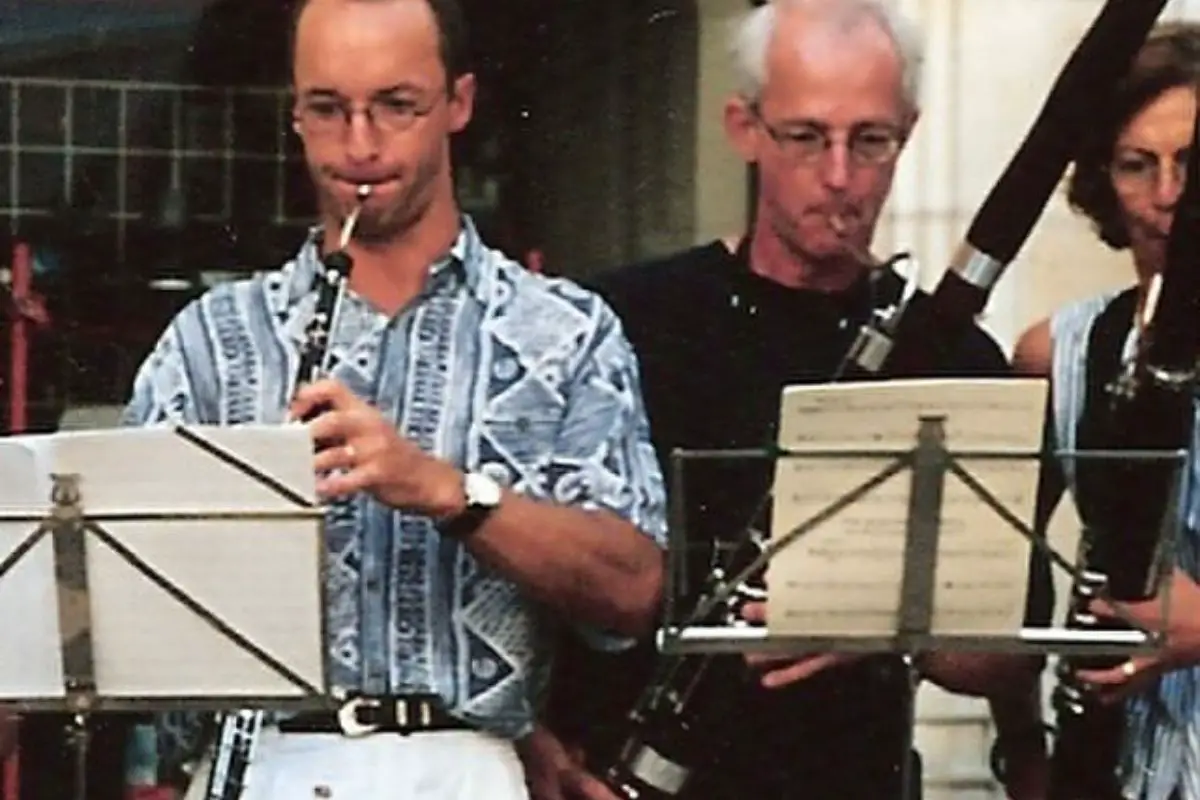 Image of three men playing musical instrument that includes english horn.