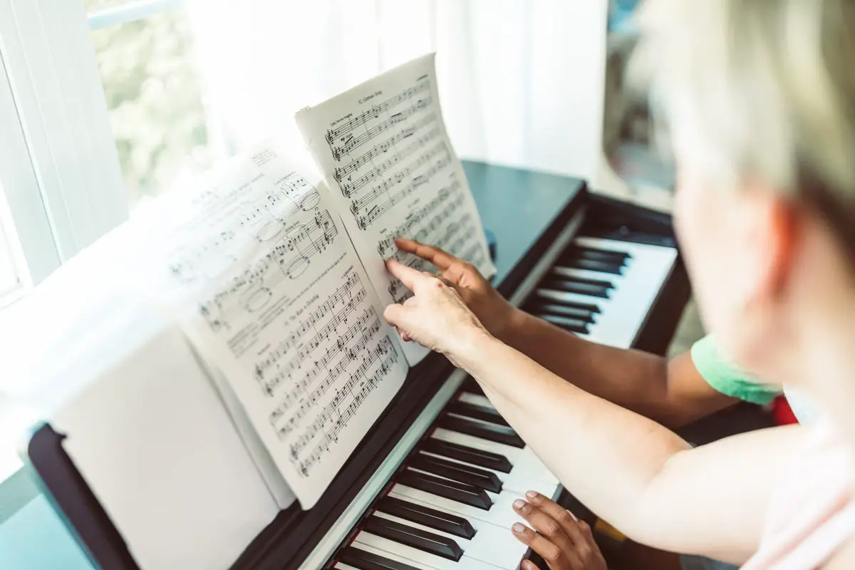 Image of two people analyzing the notations on the sheet music.