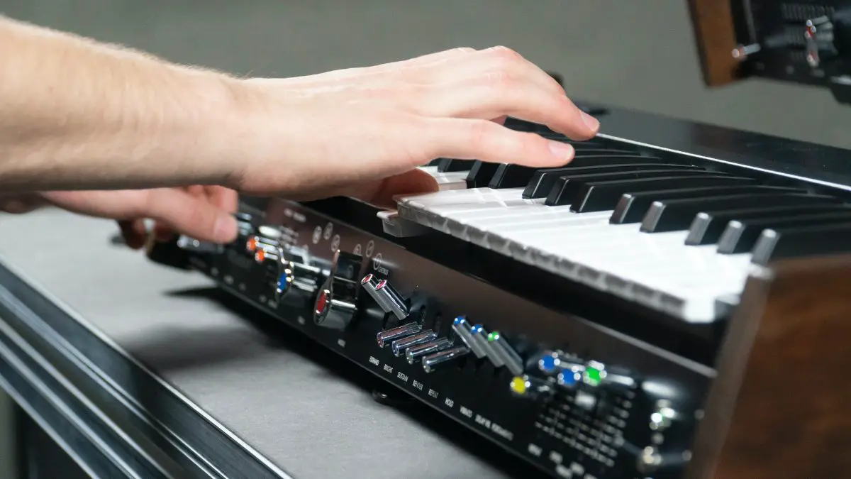 Closeup of someone playing a synthesizer. Source: unsplash