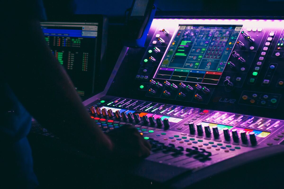 Image of a man adjusting a soundboard. Source: unsplash