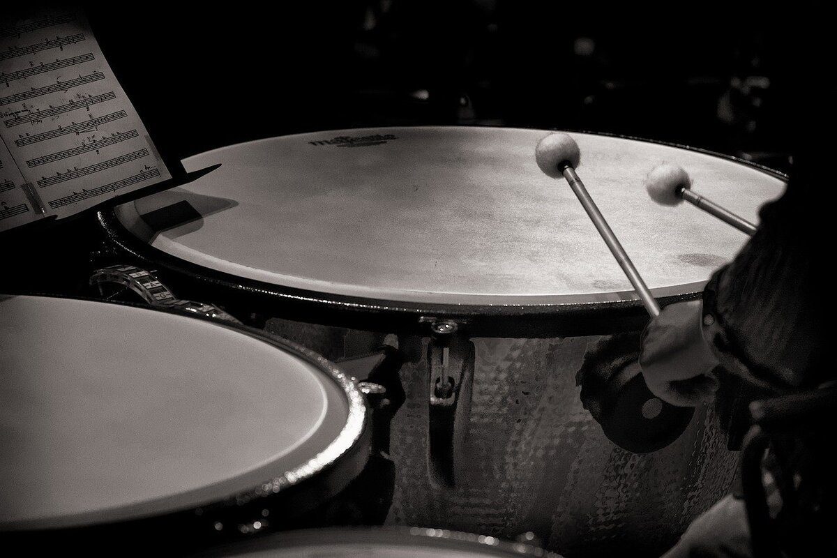 Image of a man holding a mallet in front of a kettle drum. Source: pixabay