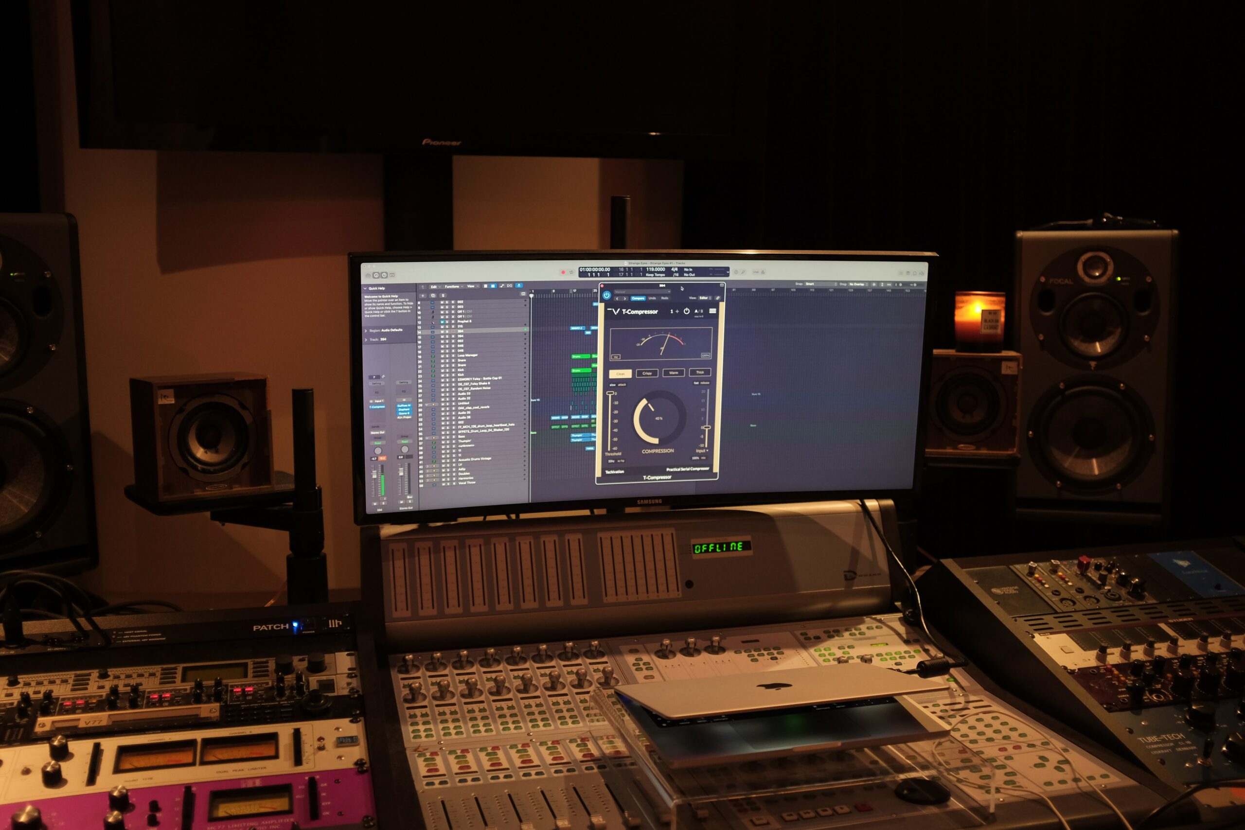 Image of a laptop and some audio mixing devices in a home recording set up.