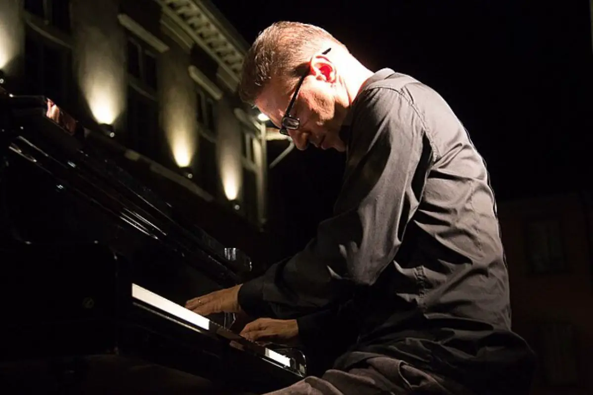 Image of a man playing the piano in a solo concert.