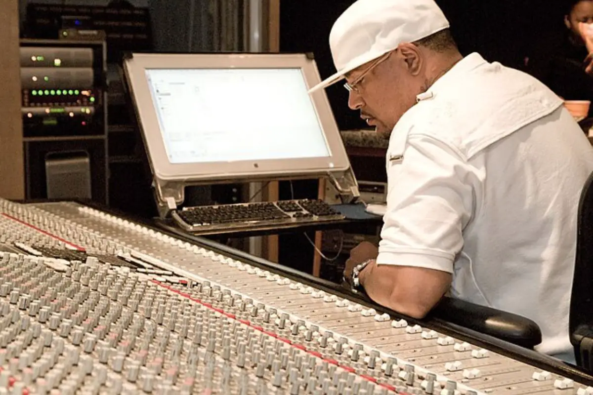 Image of a record producer mixing on a console.