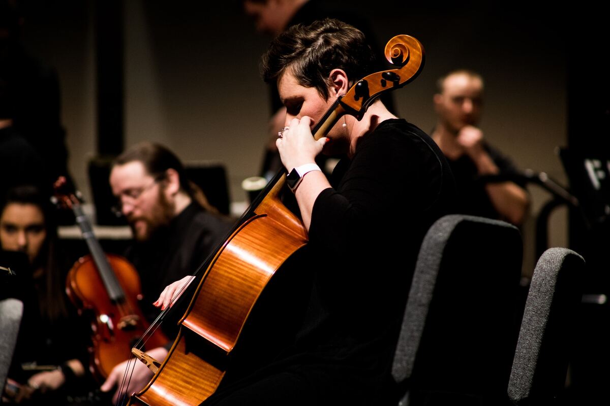 Image of a cellist in an orchestra unsplash