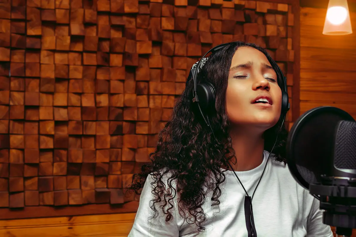 Image of a female singer in a recording studio. Source: pexels