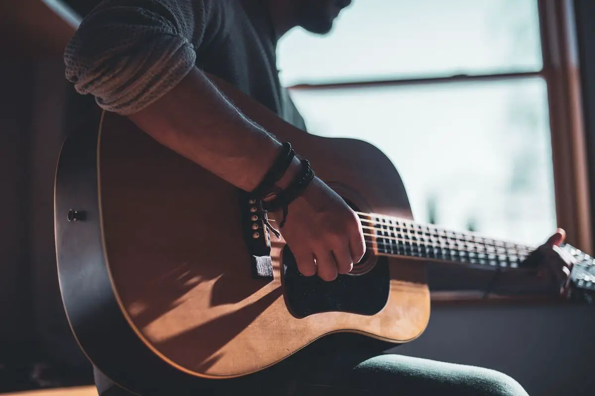 Image of a man playing the guitar. Source: Unsplash