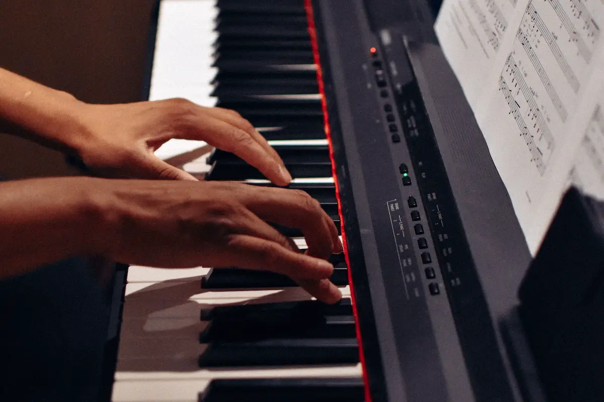 Image of a musician playing a keyboard piano. Source: pexels