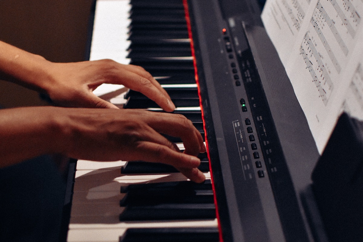 Image of a musician playing a keyboard piano. Source: Pexels