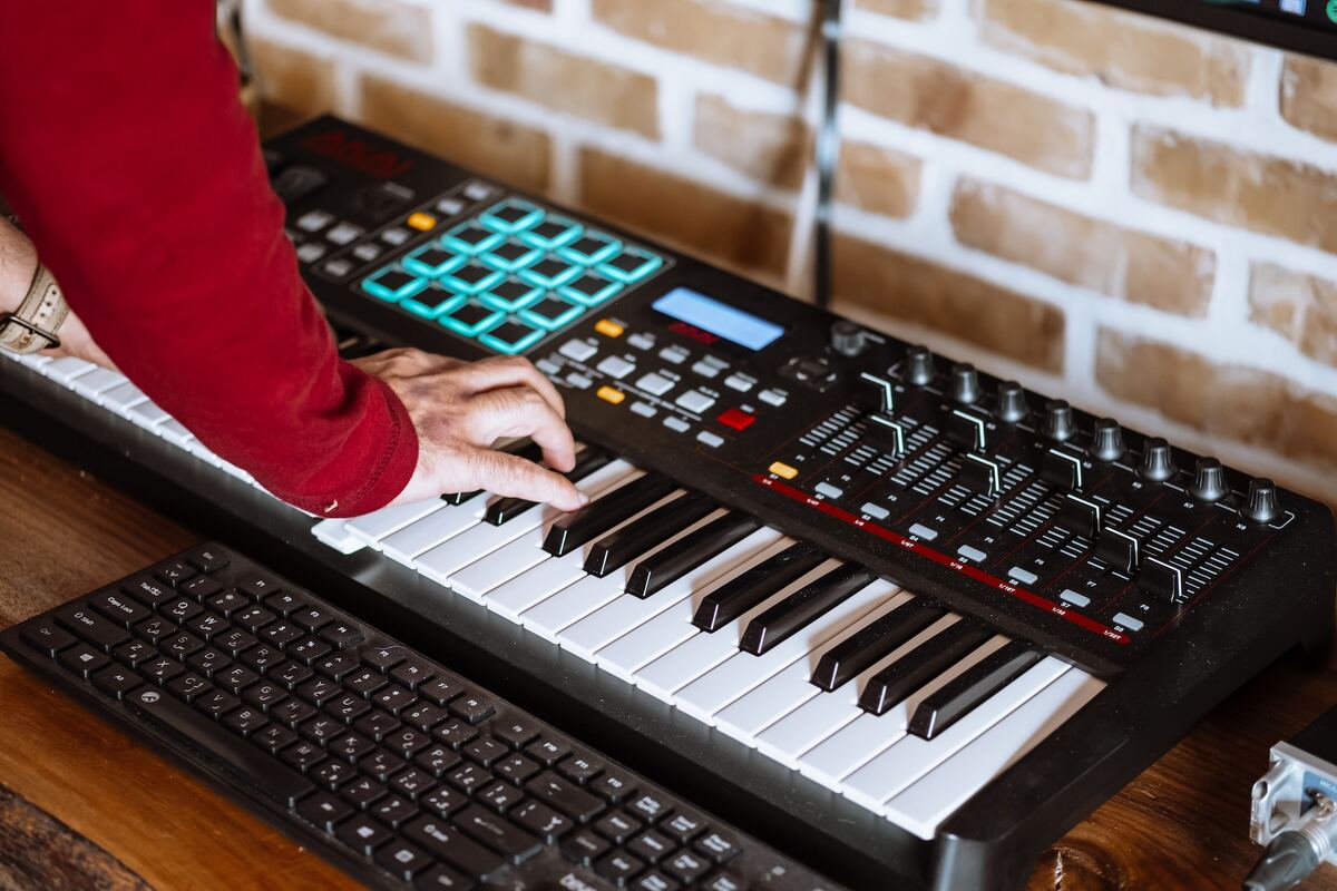 Image of a musician using a synthesizer in the studio. Source: Unsplash