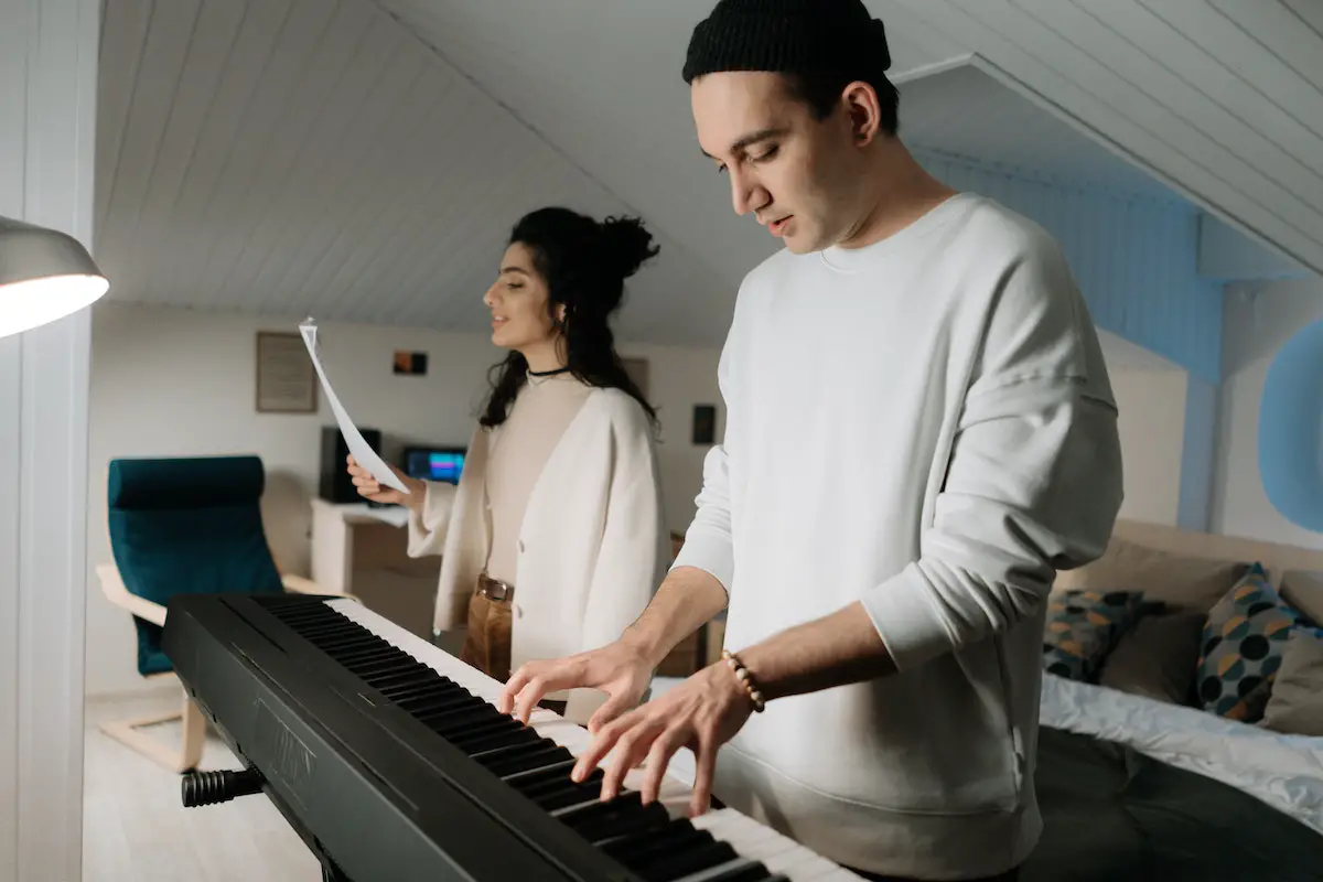 Image of a singer practicing a song with a vocal coach. Source: pexels
